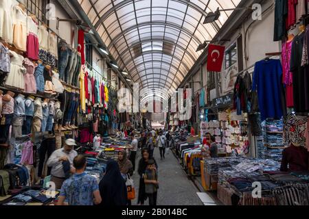 Istanbul, Türkei - 29. April 2019: Menschen im großen Basar mit Geschäften und Shopping-Leuten, mit türkischen Flaggen an den Wänden. Stockfoto