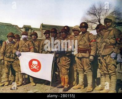 China: Japanische Soldaten zeigen in der besetzten Mandschurei (Mandschukuo), 1933, eine Totenkopf- und Kreuzknochenfahne. Der zweite chinesisch-japanische Krieg wird normalerweise von 1937 auf die endgültige Niederlage Japans im Jahr 1945 datiert, aber tatsächlich waren Japan und China seit dem Vorfall in Mukden im Jahr 1931, als Japan die Mandschurei eroberte und den Marionettenstaat Mandschukuo aufstellte, in einem Zustand des nicht erklärten Krieges. Die Japaner installierten 1932 den ehemaligen Qing-Kaiser Puyi als Staatsoberhaupt, und zwei Jahre später wurde er zum Kaiser von Manchukuo mit dem Namen Kangde (Ruhe und Tugend) erklärt. Stockfoto