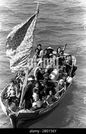 Vietnam: Eine Gruppe vietnamesischer "Bootsleute" wird auf See gerettet, 15. Mai 1984. Foto von Phil Eggman. 35 vietnamesische Flüchtlinge warten darauf, an Bord des amphibischen Kommandoschiffs USS Blue Ridge gebracht zu werden. Sie werden von einem Fischerboot 350 Meilen nordöstlich von Cam Ranh Bay, Vietnam, gerettet, nachdem sie acht Tage auf See verbracht haben. Boot People ist ein Begriff, der sich in der Regel auf Flüchtlinge oder Asylbewerber bezieht, die in Zahlen in Booten emigrieren, die manchmal alt und grob gemacht sind. Der Begriff kam in den späten 1970er-Jahren mit dem Massenabgang vietnamesischer Flüchtlinge aus dem von den Kommunisten kontrollierten Vietnam in Gebrauch. Stockfoto