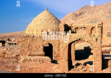 China: Ein Friedhof neben dem Dorf Tuyoq in der Nähe von Turpan, Provinz Xinjiang. Tuyoq oder Tuyugou ist ein altes Oasendorf in der Taklamakan Wüste, 70 km östlich von Turpan in einem üppigen Tal, das in die Flaming Mountains schneidet, mit einer gut erhaltenen uigurischen Ausrichtung. Es ist berühmt für seine kernlosen Trauben und eine Reihe von alten buddhistischen Meditationshöhlen in der Nähe mit Fresken, die bekannteste sind die Bezeklik Thousand Buddha Höhlen. Stockfoto