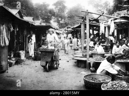 Birma/Myanmar: Ein Markt in Sagaing, Oberburma, in den 1920er Jahren. Sagaing ist die Hauptstadt der Region Sagaing (ehemals Sagaing Division) in Burma, das auch als Myanmar bekannt ist. Am Fluss Irrawaddy (Ayeyarwady) gelegen, 20 km südwestlich von Mandalay, ist Sagaing mit zahlreichen buddhistischen Klöstern ein wichtiges religiöses und monastisches Zentrum. Die Pagoden und Klöster drängen die Hügel entlang des Gramms, der parallel zum Fluss verläuft. Die zentrale Pagode, bald U Ponya Shin Pagode, ist durch eine Reihe von überdachten Treppen verbunden, die den 240 m hohen Hügel hinauf führen. Stockfoto