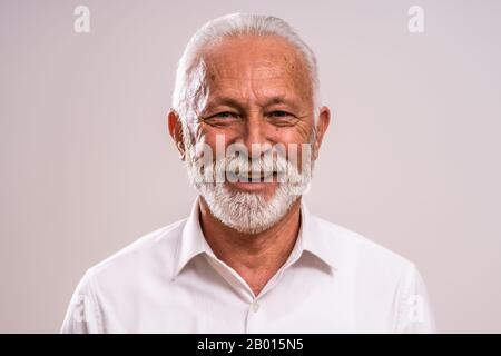 Porträt eines fröhlichen Seniors, der mit der Kamera schaut und lächelt. Stockfoto