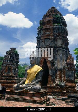 Thailand: Khmer-Stil Prang und Buddha, Wat Phra Mahathat, Ayutthaya Historical Park. Wat Phra Mahathat wurde unter der Herrschaft von Borommaracha I (Boromma Rachathirat I) oder Khun Luang Pa Ngua (1370-1388), dem dritten König des Königreichs Ayutthaya, erbaut. Ayutthaya (Ayudhya) war ein siamesisches Königreich, das von 1351 bis 1767 existierte. Ayutthaya war gegenüber ausländischen Händlern freundlich, darunter Chinesen, Vietnamesen (Annamesen), Inder, Japaner und Und später die Portugiesen, Spanier, Holländer und Franzosen, die es ihnen ermöglichten, Dörfer außerhalb der Stadtmauern zu bauen. Stockfoto