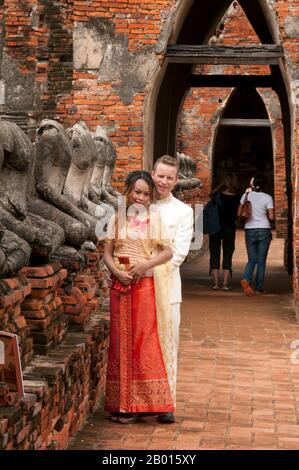 Thailand: Ein junges Paar posiert für ihre Hochzeitsfotos, Wat Chai Wattanaram, Ayutthaya Historical Park. Wat Chai Wattanaram (Watthanaram) wurde im 17. Jahrhundert unter der Herrschaft von König Prasat Thong (r. 1629-1656), der der erste König der Prasat Thong Dynastie war. Es ist sehr im Angkor/Khmer Stil gebaut. Ayutthaya (Ayudhya) war ein siamesisches Königreich, das von 1351 bis 1767 existierte. Ayutthaya war gegenüber ausländischen Händlern freundlich, darunter Chinesen, Vietnamesen (Annamesen), Inder, Japaner und Und später die europäischen Mächte, die es ihnen erlauben, Dörfer außerhalb zu errichten Stockfoto