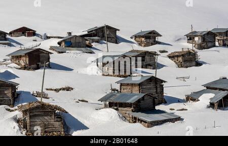 Koprulu, Türkei - 9. Mai 2019: Kleines Dorf Koprulu im Schnee mit Holzhäusern und Kabinen in einem verschneiten Tal in der Türkei. Stockfoto