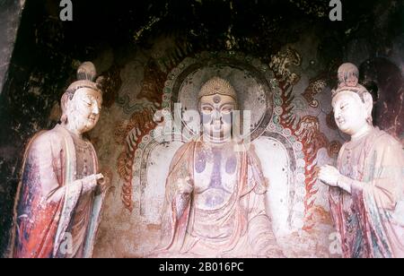 China: Buddha flankiert von Bodhisattvas, Maiji Shan Grotten, Tianshui, Provinz Gansu. Maijishan Shiku (Maiji Shan Grotten) sind eine der vier wichtigsten buddhistischen Tempelgruppen Chinas (die anderen sind Datong, Luoyang und die Mogao-Höhlen in Dunhuang). Ausgehend von den Dynastien Nördlicher Wei (386-535) und Nördlicher Zhou (557-81) schnitten Buddhisten Höhlen in die Seiten eines roten Ausschnitts, der aus den umliegenden Laubhügeln aufsteigt. Figuren des Buddha, von Bodhisattvas und Schülern wurden in härtere Felsen gehauen, die von anderswo hergebracht wurden, und in den Höhlen installiert. Stockfoto