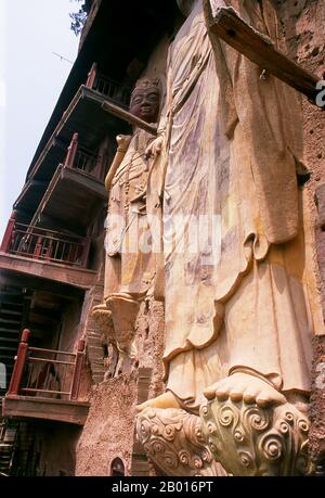 China: Der Amitabha Buddha wurde von Avalokitesvara, Maiji Shan Grotten, Tianshui, Provinz Gansu besucht. Maijishan Shiku (Maiji Shan Grotten) sind eine der vier wichtigsten buddhistischen Tempelgruppen Chinas (die anderen sind Datong, Luoyang und die Mogao-Höhlen in Dunhuang). Ausgehend von den Dynastien Nördlicher Wei (386-535) und Nördlicher Zhou (557-81) schnitten Buddhisten Höhlen in die Seiten eines roten Ausschnitts, der aus den umliegenden Laubhügeln aufsteigt. Figuren des Buddha, von Bodhisattvas und Schülern wurden in härtere Felsen gehauen, die von anderswo hergebracht wurden, und in den Höhlen installiert. Stockfoto