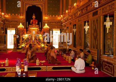 Thailand: Mönche singen im Viharn, Wat Ratchabophit, Bangkok. Wat Ratchabophit (Rajabophit) wurde unter König Chulalongkorn (Rama V, 1868-1910) erbaut. Der Tempel verbindet östliche und westliche Architekturstile und ist bekannt für seinen runden Kreuzgang, der die großen Chedi im Sri-lankischen Stil umschließt und den Ubosot (bot) im Norden mit dem Viharn im Süden verbindet. Stockfoto