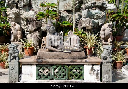 Thailand: Statue vor dem Hauptviharn, Wat Suthat, Bangkok. Wat Suthat Thepphawararam ist ein königlicher Tempel der ersten Klasse, einer von sechs solchen Tempeln in Thailand. Der Bau wurde 1807 von König Buddha Yodfa Chulaloke (Rama I) begonnen. Weitere Baumaßnahmen und Dekorationen wurden von König Buddha Loetla Nabhalai (Rama II) durchgeführt, der die Holztüren schnitzen half, aber der Tempel wurde erst unter der Herrschaft von König Jessadabodindra (Rama III) im Jahr 1847 fertiggestellt. Der Tempel ist ein schönes Beispiel des Rattanakosin architektonischen Stils. Stockfoto