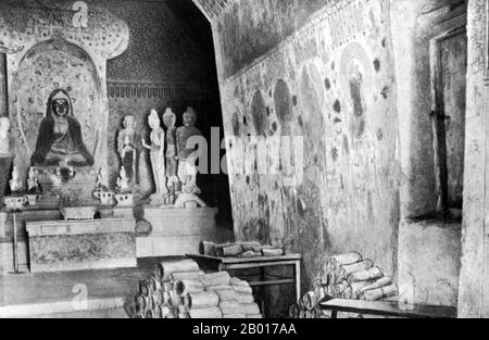 China: Dokumente aus Höhle 17, Mogao, aufgestapelt zur Untersuchung durch Sir Aurel Stein. Dunhuang, 1908. Anfang 1900s ernannte sich ein chinesischer Daoist namens Wang Yuanlu zum Hüter einiger der Mogao-Höhlen. Wang entdeckte einen zugemauerten Bereich hinter einer Seite eines Korridors, der zu einer Haupthöhle führte. Hinter der Wand befand sich eine kleine Höhle, die mit einem riesigen Hortfund von Handschriften aus den Jahren 406 bis 1002 u.Z. gefüllt war. Dazu gehörten alte Hanfpapierrollen in Chinesisch und vielen anderen Sprachen, Gemälde auf Hanf, Seide oder Papier, zahlreiche beschädigte Buddhafiguren und andere buddhistische Utensilien. Stockfoto