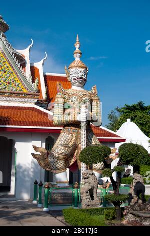 Thailand: Schutzfigur oder Yaksa am Tor zum Wat Arun (Tempel der Morgenröte), Bangkok. In der buddhistischen Mythologie sind die Yakṣa (Yaksha oder Yak) die Begleiter von Vaiśravaṇa, dem Wächter des nördlichen Viertels, einem wohltätigen gott, der die Rechtschaffenen beschützt. Der Begriff bezieht sich auch auf die zwölf himmlischen Generäle, die Bhaiṣajyaguru, den Medizin-Buddha, bewachen. Wat Arun Rajwararam (Tempel der Morgenröte), voller Name Wat Arunratchawararam Ratchaworamahawihan, ist ein thailändischer buddhistischer Tempel am Thonburi-Westufer des Chao Phraya-Flusses in Bangkok. Es ist nach Aruna, dem indischen Gott der Morgenröte, benannt. Stockfoto