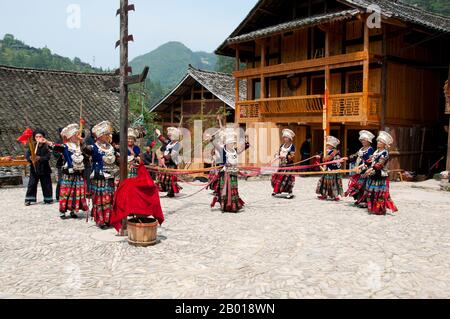 China: Miao-Frauen tanzen im Dorf Langde Shang, südöstlich von Kaili, Provinz Guizhou. Die Miao sind eine sprachlich und kulturell verwandte Gruppe von Menschen, die von der Regierung der Volksrepublik China als eine der 55 offiziellen Minderheitengruppen anerkannt wird. Miao ist ein chinesischer Begriff und spiegelt nicht die Selbstbezeichnungen der Teilgruppen wider, zu denen (mit einigen Schreibvarianten) Hmong, Hmu, A Hmao und Kho (Qho) Xiong gehören. Die Miao leben hauptsächlich in Südchina, in den Provinzen Guizhou, Hunan, Yunnan, Sichuan, Guangxi, Hainan, Guangdong und Hubei. Stockfoto