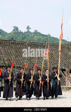 China: Miao-Männer spielen das Lusheng, ein traditonales Miao-Instrument, im Dorf Langde Shang, südöstlich von Kaili, Provinz Guizhou. Der Lusheng (auch lu sheng geschrieben; in der Hmong-Sprache Qeej und ausgeprägte Gaeng) ist ein chinesisches Musikinstrument mit mehreren Bambuspfeifen, die jeweils mit einem freien Rohr ausgestattet sind, das in einem langen Blasrohr aus Hartholz montiert ist. Es hat meistens fünf oder sechs Pfeifen mit unterschiedlichen Tonhöhen und ist somit ein polyphones Instrument. Es ist in Größen von sehr klein bis zu mehreren Metern Länge erhältlich. Stockfoto