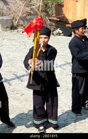 China: Miao-Mann spielt das Lusheng, ein traditonales Miao-Instrument, im Dorf Langde Shang, südöstlich von Kaili, Provinz Guizhou. Der Lusheng (auch lu sheng geschrieben; in der Hmong-Sprache Qeej und ausgeprägte Gaeng) ist ein chinesisches Musikinstrument mit mehreren Bambuspfeifen, die jeweils mit einem freien Rohr ausgestattet sind, das in einem langen Blasrohr aus Hartholz montiert ist. Es hat meistens fünf oder sechs Pfeifen mit unterschiedlichen Tonhöhen und ist somit ein polyphones Instrument. Es ist in Größen von sehr klein bis zu mehreren Metern Länge erhältlich. Stockfoto