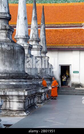 Thailand: Mönche und kleinere Chedis rund um den Hauptchedi, Wat Phra Mahathat, Nakhon Sri Thammarat. Wat Phra Mahathat Woramahawihan, allgemein abgekürzt zu Wat Mahathat, oder ‘Tempel des Großen Chedi’, ist der am meisten verehrte und wichtigste Tempel in Nakhon Si Thammarat und in der Tat im Süden Thailands. Es gilt als zur Zeit der Stadtgründung erbaut und soll eine Zahnreliquie des Buddha enthalten. Die südthailändische Überlieferung berichtet, dass die Gründer des Tempels Prinz Thanakuman und seine Königin Hemchala waren, die Buddha-Reliquien zu hat Sai Kaeo brachten. Stockfoto