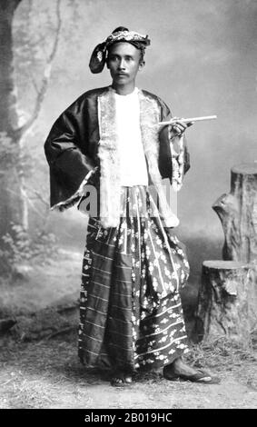 Burma/Myanmar: Studioportrait eines jungen Burmans mit einem Cheroot. Foto von Philip Adolphe Klier (1845. - 27. März 1911), wahrscheinlich Rangun/Yangon, 1895. Philip Adolphe Klier war ein deutscher Fotograf, der vor allem für seine Fotografien des kolonialen Burma/Myanmar bekannt war. 1871 war er professioneller Fotograf in Moulmein, Burma. Zu seinem Geschäft gehörten Arbeiten als Optiker, Uhrmacher und Juwelier sowie die Leitung der Firma Murken & Klier. ‘1880 zog Klier nach Rangun, Burmas größter Stadt und dem Zentrum der indo-britischen Macht. Stockfoto