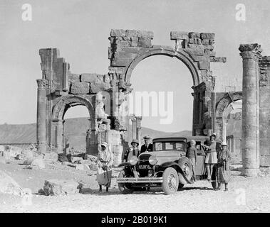 Syrien: Europäische Touristen am dreifachen Torbogen in Palmyra (Tadmur), c. 1900. Palmyra war eine alte Stadt in Syrien. Im Altertum war sie eine wichtige Stadt Zentralsyriens, die sich in einer Oase 215 km nordöstlich von Damaskus und 180 km südwestlich des Ezor in Deir befand. Sie war lange Zeit eine wichtige Karawanenstadt für Reisende, die die syrische Wüste durchquerten und war als die "Braut der Wüste" bekannt. Die Stadt ist auch unter dem alten semitischen Namen Tadmor, Tadmur oder Tudmur bekannt (was „die Stadt, die abstößt“ in Amorite und „die unbeugsame Stadt“ in Aramäisch bedeutet). Stockfoto