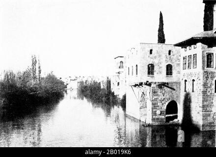 Syrien: Der Fluss Orontes ('Asi') bei Hama, c. 1914. Die Orontes erhebt sich in den großen Quellen von Labweh auf der Ostseite des Beqaa-Tals, ganz in der Nähe der Brunnen des nach Süden fließenden Litani, und sie verläuft nach Norden, parallel zur Küste, und fällt 2000 Fuß (600 m) durch eine felsige Schlucht. Aus diesem Grund dehnt es sich in den Homer See aus, der bereits in der Antike aufgestaucht wurde. Das Tal verbreitert sich jetzt in den reichen Bezirk von Hamah (Hamaih-Epiphaneia), unter dem liegen die breiten Wiesen-Länder von Amykes, mit den Standorten der alten Apamea und Larissa. Stockfoto