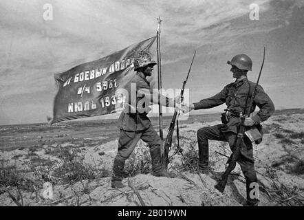 Mongolei: Siegreiche sowjetische Truppen heben eine rote Regimentsflagge bei Khalkhin Gol. Foto von Pavel Troshkin (1909-1944), 1939. Die Schlachten von Khalkhin Gol waren die entscheidenden Kämpfe des nicht deklarierten sowjetisch-japanischen Grenzkrieges, der 1939 zwischen der Sowjetunion, der Mongolei und Japan geführt wurde. Sie wurden nach dem Fluss Khalkhin Gol benannt, der durch das Schlachtfeld fließt. In Japan wird die entscheidende Schlacht des Konflikts nach einem nahegelegenen Dorf als Nomonhan-Vorfall (Nomonhan Jiken) bezeichnet und war eine totale Niederlage für ihre Armee. Stockfoto