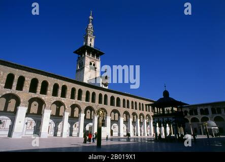 Syrien: Minarett der Braut und der zentrale Innenhof, Umayyad-Moschee, Damaskus. Die Umayyad-Moschee, auch bekannt als die große Moschee von Damaskus, ist eine der größten und ältesten Moscheen der Welt. Es gilt als der viertheiligste Ort im Islam. Der Bau der Moschee soll kurz nach der arabischen Eroberung von Damaskus im Jahr 634 begonnen haben. Die Moschee enthält einen Schrein, der Johannes dem Täufer gewidmet ist, sowie das Grab von Saladin. Stockfoto