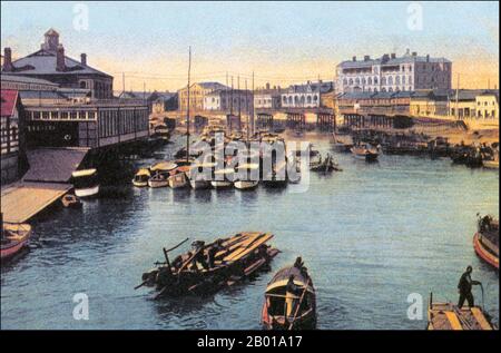 China: Suzhou Creek und Shanghai Rowing Club. Postkarte, c. 1920. Der Suzhou Creek (auch Wusong River genannt) ist ein Fluss in China, der durch das Stadtzentrum von Shanghai fließt. Es ist nach Suzhou benannt, einer Stadt in der benachbarten Provinz Jiangsu, die vor dem Aufstieg Shanghais zur Metropole die vorherrschende Stadt in diesem Gebiet war. Suzhou Creek, eines der Hauptauslässe des Tai-Sees, hat eine Länge von 125 km, davon 54 km in der Verwaltungsregion Shanghai und 24 km in den stark urbanisierten Teilen der Stadt. Der Fluss mündet am nördlichen Ende des Bundes in den Huangpu. Stockfoto