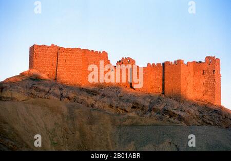 Syrien: Burg Qala’at Ibn Maan über den Ruinen von Palmyra. Die arabische Burg Qala’at Ibn Maan (auch bekannt als Fakhr-al-DIN al-Maani), die auf einem Hügel über den Ruinen liegt, wurde von den Mamluken im 13.. Jahrhundert uralt erbaut. Palmyra war eine alte Stadt in Syrien. Es war eine wichtige Stadt in Zentral-Syrien, in einer Oase 215 km nordöstlich von Damaskus und 180 km südwestlich des eufratischen Normes bei Deir EZ-Zor gelegen. Sie war lange Zeit eine wichtige Karawanenstadt für Reisende, die die syrische Wüste durchquerten und war als die Braut der Wüste bekannt. Stockfoto