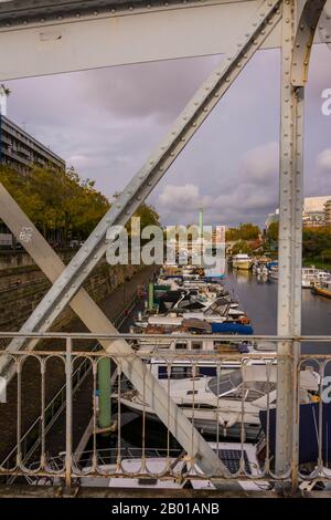 Paris, Frankreich - 11. November 2019: Geländer des Mornay-Laufsteg, im Kanal des Arsenalhafens. Im Hintergrund die Spalte des Denkmals an Stockfoto