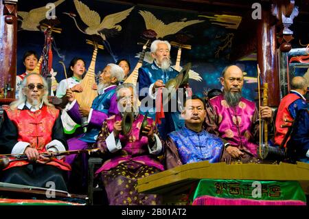 China: Das Naxi (Nakhi) Folk Orchestra, Naxi Orchestra Hall, Lijiang Old Town, Provinz Yunnan. Naxi-Musik ist 500 Jahre alt und hat mit ihrer Mischung aus literarischen Texten, poetischen Themen und musikalischen Stilen der Tang-, Song- und Yuan-Dynastien sowie einigen tibetischen Einflüssen einen eigenen, einzigartigen Stil und Züge entwickelt. Es gibt drei Hauptstile: Baisha, Dongjing und Huangjing, alle mit traditionellen chinesischen Instrumenten. Die Naxi oder Nakhi sind eine ethnische Gruppe, die am Fuße des Himalaya im Nordwesten der Provinz Yunnan lebt. Stockfoto