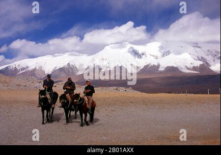 China: Kirgisische Reiter am Karakul-See auf dem Karakorum-Highway, Xinjiang. Zwei kleine Siedlungen kirgisischer (kirgisischer oder kirgisischer) Nomaden liegen am Karakul-See hoch oben im Pamir-Gebirge. Die Besucher können in einem ihrer Mobilheime oder Jurten übernachten – Kirgisen kommen auf Reisende zu und bieten an, diese Unterkunft zu arrangieren. Die Kirgisen bilden eine der 56 Volksgruppen, die von der Volksrepublik China offiziell anerkannt werden. In China gibt es mehr als 145.000 Kirgisen. Stockfoto