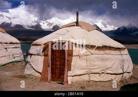 China: Kirgisisch-Jurten am Karakul-See auf dem Karakorum Highway, Xinjiang. Zwei kleine Siedlungen kirgisischer (kirgisischer oder kirgisischer) Nomaden liegen am Karakul-See hoch oben im Pamir-Gebirge. Die Besucher können in einem ihrer Mobilheime oder Jurten übernachten – Kirgisen kommen auf Reisende zu und bieten an, diese Unterkunft zu arrangieren. Die Kirgisen bilden eine der 56 Volksgruppen, die von der Volksrepublik China offiziell anerkannt werden. In China gibt es mehr als 145.000 Kirgisen. Der Zhongba Gonglu oder Karakoram Highway ist ein wahres Ingenieurswunder. Stockfoto