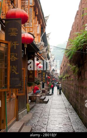 China: Alte Häuser dicht bis zur alten Stadtmauer, Fenghuang, Provinz Hunan. Fenghuang ist Chinesisch für Phoenix und bezieht sich auf den mythischen heiligen feuervogel, der in den Mythologien der Peter, Griechen, Römer, Ägypter, Chinesen, Und (nach Sanchuniathon) die Phönizier. Die Legende besagt, dass zwei Phönixe, die die Stadt entdeckten, einige Zeit über dem Kopf schwebten, bevor sie widerwillig wegflogen. Die Stadt Fenghuang ist eine gut erhaltene antike Stadt, die angeblich aus dem Jahr 248 v. Chr. stammt. Hier leben die Minderheiten Miao und Tujia. Stockfoto