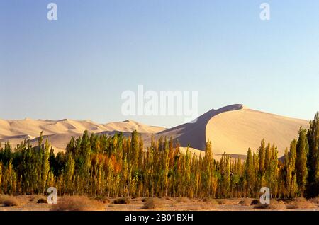 China: Die singenden Sanddünen von Mingsha Shan (Mingsha Hills) in der Kumtagh-Wüste, Provinz Gansu. Mingsha Shan (Singende Sanddünen) liegen etwa 4km südlich von Dunhuang. Sie sind die größten und eindrucksvollsten Sanddünen in China. Die Hauptdünen erheben sich zwischen 250m und 300m. Sie werden ‘Singing Sands’ genannt, weil die sich verschiebenden Sandkörner bei starken Winden ein brummendes Geräusch verursachen. Die Kumtagh-Wüste ist ein Teil der Taklamakan-Wüste, die östlich-südöstlich der Wüste Lop liegt. Stockfoto