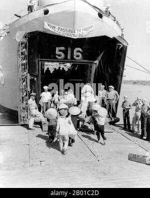 Vietnam: Vietnamesische Flüchtlinge besteigen ein Landungsschiff der US Navy in Haiphong für ihre Reise südlich nach Saigon, Oktober 1954. Vietnamesische Flüchtlinge besteigen die USS Calaveras County (LST-516) für ihre Reise von Haiphong, Nordvietnam, nach Saigon, Südvietnam während der Operation Passage to Freedom, Oktober 1954. Diese Operation evakuierte Tausende vietnamesischer Flüchtlinge aus dem damals neu geschaffenen kommunistischen Nordvietnam nach proamerikanischem Südvietnam. Bis zum Ende der Operation hatte die Marine mehr als 293.000 Einwanderer, darunter viele katholische Flüchtlinge, nach Süden transportiert. Stockfoto