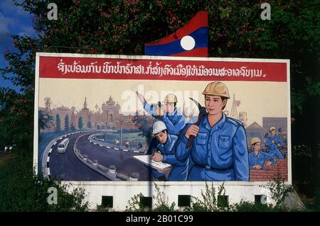 Laos: Politisches Plakat im Stil des revolutionären Sozialistischen Realismus auf den Straßen von Vientiane. Sozialistischer Realismus ist ein Stil realistischer Kunst, der in der Sowjetunion entwickelt wurde und in anderen kommunistischen Ländern zu einem dominanten Stil wurde. Der sozialistische Realismus ist ein teleologisch orientierter Stil, der die Ziele des Sozialismus und Kommunismus fördern soll. Obwohl verwandt, sollte sie nicht mit dem sozialen Realismus verwechselt werden, einer Art Kunst, die Themen von sozialem Interesse realistisch darstellt. Im Gegensatz zum sozialen Realismus verherrlicht der sozialistische Realismus oft die Rolle der Armen. Stockfoto