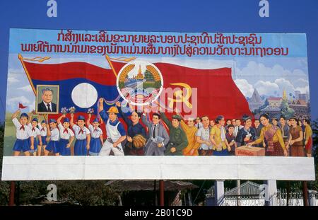 Laos: Politisches Plakat im Stil des revolutionären Sozialistischen Realismus auf den Straßen von Vientiane. Sozialistischer Realismus ist ein Stil realistischer Kunst, der in der Sowjetunion entwickelt wurde und in anderen kommunistischen Ländern zu einem dominanten Stil wurde. Der sozialistische Realismus ist ein teleologisch orientierter Stil, der die Ziele des Sozialismus und Kommunismus fördern soll. Obwohl verwandt, sollte sie nicht mit dem sozialen Realismus verwechselt werden, einer Art Kunst, die Themen von sozialem Interesse realistisch darstellt. Im Gegensatz zum sozialen Realismus verherrlicht der sozialistische Realismus oft die Rolle der Armen. Stockfoto