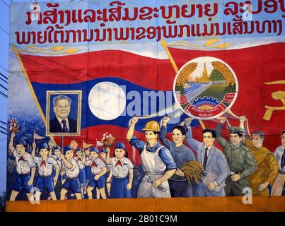 Laos: Die Kinder tragen ein Bild von Kaysone Phomvihane, Präsident von Laos von 1991 bis zu seinem Tod im Jahr 1992, einem politischen Plakat im revolutionären sozialistischen Realismus auf den Straßen von Vientiane. Kaysone Phomvihane (13. Dezember 1920 - 21. November 1992) war ab 1955 Führer der Laos-Partei der Revolution des Volkes. Von 1975 bis 1991 war er erster Premierminister der Demokratischen Volksrepublik Laos und von 1991 bis zu seinem Tod im Jahr 1992 Präsident. Stockfoto