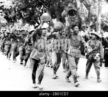 Vietnam: Die fröhlichen Viet Minh-Truppen winken der Bevölkerung der Stadt zu und genießen eine Siegesparade durch die Straßen von Hanoi, 9. Oktober 1954. Der erste Indochinakrieg (auch bekannt als französischer Indochinakrieg, antifranzösischer Krieg, französisch-vietnamesischer Krieg, französisch-vietnamesischer Krieg, Indochinakrieg, Schmutziger Krieg in Frankreich und antifranzösischer Widerstandskrieg im heutigen Vietnam) wurde in Französisch-Indochina vom 19. Dezember 1946 bis zum 1. August 1954 geführt. Der Krieg fand zwischen dem französischen Fernost-Expeditionskorps der Französischen Union und den Việt Minh unter der Führung von Hồ Chí Minh und Võ Nguyên Giáp statt. Stockfoto