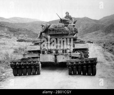 Vietnam: Eine auf einem Tank montierte Minenwalze auf einem Patton von M48, der Südvietnams Highway 19, um 1966, abräumte. Der zweite Indochina-Krieg, in Amerika als Vietnamkrieg bekannt, war ein militärischer Konflikt aus der Zeit des Kalten Krieges, der sich in Vietnam, Laos und Kambodscha vom 1. November 1955 bis zum Fall Saigons am 30. April 1975 ereignete. Dieser Krieg folgte dem ersten Indochina-Krieg und wurde zwischen Nordvietnam, unterstützt von seinen kommunistischen Verbündeten, und der Regierung von Südvietnam, unterstützt von den USA und anderen antikommunistischen Nationen, geführt. Stockfoto