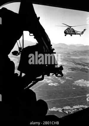 Vietnam: Blick aus der Position des Türschützers aus den USA Marine Corps Sikorsky UH-34D Seepferd-Hubschrauber über Vietnam; im Vordergrund steht das M-60-Maschinengewehr des Schützen, ca. 1965. Der zweite Indochina-Krieg, in Amerika als Vietnamkrieg bekannt, war ein militärischer Konflikt aus der Zeit des Kalten Krieges, der sich in Vietnam, Laos und Kambodscha vom 1. November 1955 bis zum Fall Saigons am 30. April 1975 ereignete. Dieser Krieg folgte dem ersten Indochina-Krieg und wurde zwischen Nordvietnam, unterstützt von seinen kommunistischen Verbündeten, und der Regierung von Südvietnam, unterstützt von den USA und anderen antikommunistischen Nationen, geführt. Stockfoto