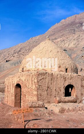 China: Ein Grab auf dem Friedhof neben dem Dorf Tuyoq in der Nähe von Turpan, Provinz Xinjiang. Tuyoq oder Tuyugou ist ein altes Oasendorf in der Taklamakan Wüste, 70 km östlich von Turpan in einem üppigen Tal, das in die Flaming Mountains schneidet, mit einer gut erhaltenen uigurischen Ausrichtung. Es ist berühmt für seine kernlosen Trauben und eine Reihe von alten buddhistischen Meditationshöhlen in der Nähe mit Fresken, die bekannteste sind die Bezeklik Thousand Buddha Höhlen. Stockfoto