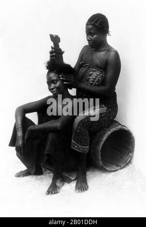 Tansania: Swahili-Friseurin bei der Arbeit, Sansibar, Britisch-Ostafrika, ca. 1890s. Beide Frauen tragen Kanga oder bedruckte Baumwoll-Wrap-Around-Röcke, die charakteristisch für die Region sind. Die Suaheli sind eine ethnische Gruppe und Kultur der Bantu, die in Ostafrika vor allem in den Küstenregionen und den Inseln Kenia, Tansania und Nord-Mosambik anzutreffen sind. Der Name Swahili leitet sich vom arabischen Wort sawahil ab, was "Küstenbewohner" bedeutet, und sie sprechen die Swahili-Sprache. Die Suaheli sind ursprüngliche Bantu-Bewohner an der Küste Ostafrikas, in Kenia, Tansania und Mosambik. Stockfoto