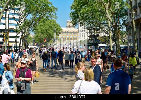 Barcelona, SPANIEN - 7. APRIL 2017: Menschen, die am oberen Abschnitt der La Rambla in Barcelona, Spanien, spazieren gehen. Tausende von Menschen gehen täglich von diesem beliebten Stockfoto