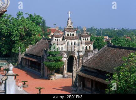 Vietnam: Äußere Kapelle in der Phat Diem Kathedrale, Provinz Ninh Binh. Die Kathedrale Phat Diem befindet sich im Bezirk Kim Son der Provinz Ninh Binh. Es ist eine der berühmtesten und ungewöhnlichsten Kirchen in Vietnam, und die Architektur ist eine Synthese chinesisch-vietnamesischer und französisch-katholischer Stile. Der Katholizismus kam zu früh zu Phat Diem. Alexandre de Rhodes, ein Jesuit aus Avignon, der das vietnamesische schriftsystem quoc ngu entwickelt hat, predigte hier bereits 1627, aber es war ein vietnamesischer Priester, Pater Tran Luc, der den Bau der wunderbaren Kathedrale von Phat Diem konzipierte und organisierte. Stockfoto