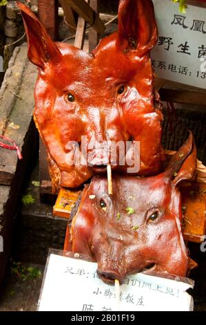 China: Flachgesichtige Schweine, Fenghuang Delikatesse, Fenghuang, Provinz Hunan. Fenghuang ist Chinesisch für Phoenix und bezieht sich auf den mythischen heiligen feuervogel, der in den Mythologien der Perser, Griechen, Römer, Ägypter, Chinesen, Und (laut Sanchuniathon) die Phönizier. Der Legende nach schwebten zwei Phoenixe bei der Entdeckung der Stadt über längere Zeit, bevor sie widerwillig wegflogen. Die Stadt Fenghuang ist eine gut erhaltene antike Stadt, die angeblich aus dem Jahr 248 BCE stammt. Hier leben die Minderheiten Miao und Tujia. Stockfoto