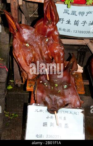 China: Flachgesichtige Schweine, Fenghuang Delikatesse, Fenghuang, Provinz Hunan. Fenghuang ist Chinesisch für Phoenix und bezieht sich auf den mythischen heiligen feuervogel, der in den Mythologien der Perser, Griechen, Römer, Ägypter, Chinesen, Und (laut Sanchuniathon) die Phönizier. Der Legende nach schwebten zwei Phoenixe bei der Entdeckung der Stadt über längere Zeit, bevor sie widerwillig wegflogen. Die Stadt Fenghuang ist eine gut erhaltene antike Stadt, die angeblich aus dem Jahr 248 BCE stammt. Hier leben die Minderheiten Miao und Tujia. Stockfoto