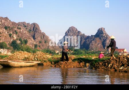 Vietnam: Bewässernde Reisfelder in der Nähe von Kenh GA, Provinz Ninh Binh. Im schwimmenden Dorf Kenh GA oder „Chicken Canal“ verbringt fast die gesamte Gemeinde ihr Leben auf dem Wasser, und das Dorf ist nur mit dem Boot erreichbar. Nordvietnam, das Gebiet am Delta des Roten Flusses mit seiner Hauptstadt in Hanoi, erstreckt sich von der chinesischen Grenze im Norden bis zum Fluss Ma in der Provinz Thanh Hoa im Süden. Im Westen bilden der Truong-Sohn oder die „Long Mountains“ und die Grenze zu Lao die Grenze; im Osten liegt Vinh Bac Bo, der „nördliche Golf“. Stockfoto