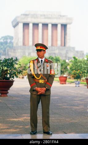 Vietnam: Wachen am Ho-Chi-Minh-Mausoleum, Ba-Dinh-Platz, Hanoi. Der BA-Dinh-Platz ist für die Vietnamesen von besonderer Bedeutung, da Ho Chi Minh hier vor einer Menschenmenge von mehr als 100.000 Menschen am 2. September 1945 die Unabhängigkeit der Nation von Frankreich erklärte. Das Mausoleum von Ho Chi Minh befindet sich auf der Westseite des Ba Dinh Platzes, einer schweren grauen Struktur, die von Stein überblickt ist, der vom Marble Mountain in der Nähe von Danang abgebaut wurde. Ho Chi Minh hat ausdrücklich darum gebeten, dass er eingeäschert wird und seine Asche in ganz Vietnam verstreut wird, was die nationale Einheit symbolisiert, der er sein Leben gewidmet hatte. Stockfoto