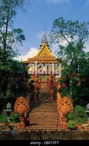 Kambodscha: Naga-Treppe, die nach Wat Phnom, Phnom Penh führt. Phnom Penh liegt auf der westlichen Seite des Mekong an dem Punkt, wo er durch den SAP River verbunden wird und sich in den Bassac River teilt. Dies ist ein Treffpunkt von vier großen Wasserstraßen, die in Kambodscha als Chatomuk oder „Four Faces“ bekannt sind. Es ist schon kurz nach der Stillegung von Angkor Mitte des 14. Jahrhunderts im Zentrum des kambodschanischen Lebens und seit 1866 die Hauptstadt. Eine elegante französisch-kambodschanische Stadt mit breiten Boulevards und buddhistischen Tempeln, galt sie bis zum Aufstieg der Roten Khmer als eines der Juwelen Südostasiens. Stockfoto