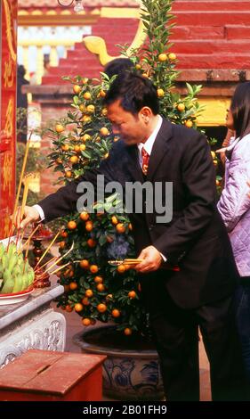 Vietnam: TET-Feiern (Vietnamesisches Neujahr) in der Tran Quoc Pagode, Ho Tay (Westsee), Hanoi. Der älteste Tempel von Hanoi, Chua Tran Quoc, befindet sich auf einer winzigen Insel westlich des Damm bei Ho Tay. Der genaue Ursprung der Pagode ist unbekannt, doch wurde sie nach der Legende ursprünglich während der Herrschaft von König Ly Nam De (544-548) am Ufer des Roten Flusses in einem kurzen Interregnum während des Jahrtausends der chinesischen Besatzung errichtet. Vietnams größter Nationalfeiertag ist Tet – genauer gesagt Tet Nguyen Dan, „Festival of the First Day“ –, der mit dem ersten Tag des Mondneujahrs zusammenfällt. Stockfoto