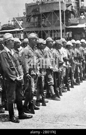 Vietnam: Bewaffnete japanische Truppen in Saigon unter britischer Kontrolle nach japanischer Kapitulation, 1945. Im September 1945 besetzten 20.000 britische Truppen der 20. Indischen Division Saigon unter dem Kommando von General Sir Douglas David Gracey. Während der Potsdamer Konferenz im Juli 1945 hatten sich die Alliierten darauf geeinigt, dass Großbritannien die Kontrolle über Vietnam südlich des 16. Breitengrades (damals Teil der französischen Indochina) von den japanischen Besatzern übernimmt. In der Zwischenzeit erklärte Ho Chi Minh die vietnamesische Unabhängigkeit von der französischen Herrschaft und in Saigon wurden große Demonstrationen für die Unabhängigkeit und gegen Frankreich abgehalten. Stockfoto